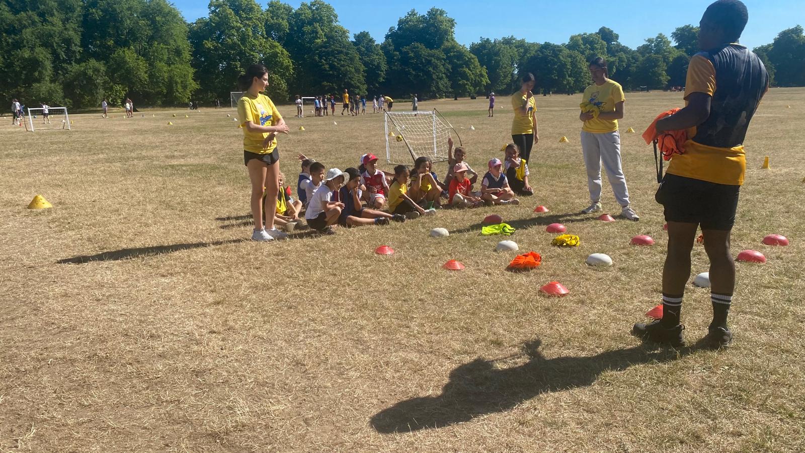 Tots Ages 3-4 Sunday Football 2 coaches briefing kids during football camp
