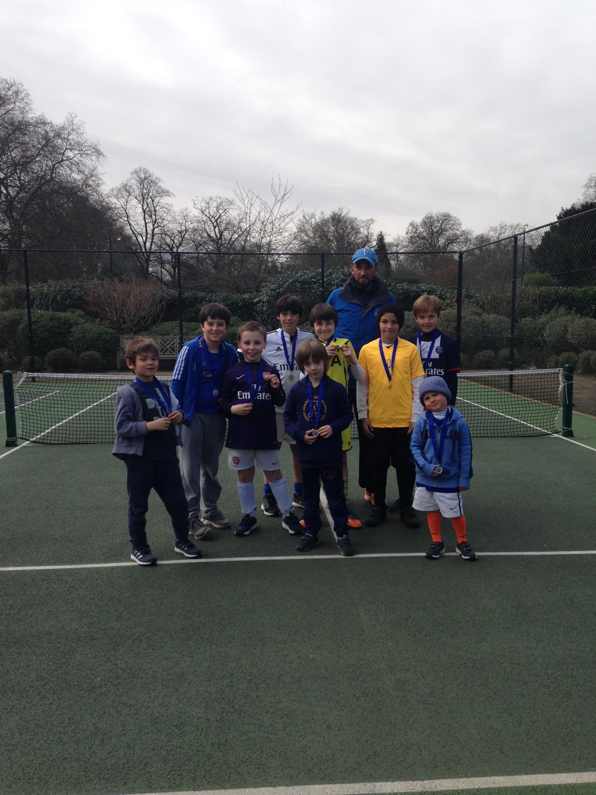 Ages 5-13 Sunday Football 2 junior tennis team celebrating with medals