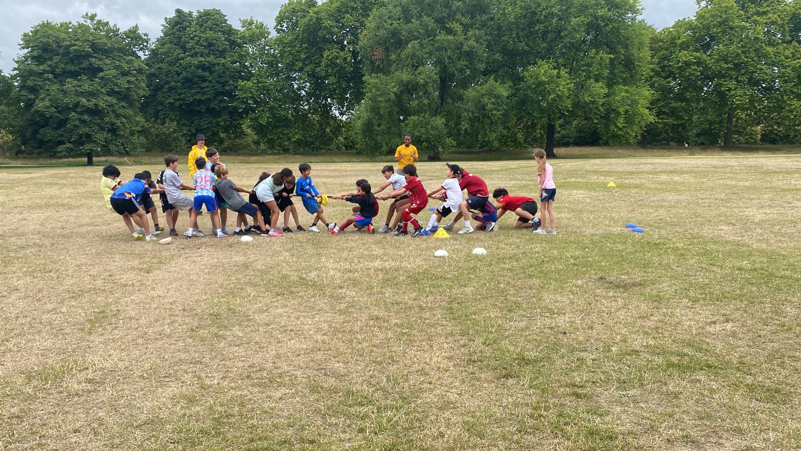 Ages 5-13 Multi-Sport 2 Children playing tug-of-war during a First Touch FC kids football coaching event in Hyde Park London